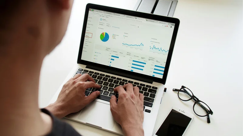 Person von hinten am MacBook mit Analytics-Dashboard — IT-Dienstleister wechseln ohne Datenverlust
