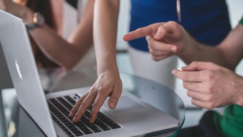 Team zeigt auf Laptop-Bildschirm — Security-Awareness-Training