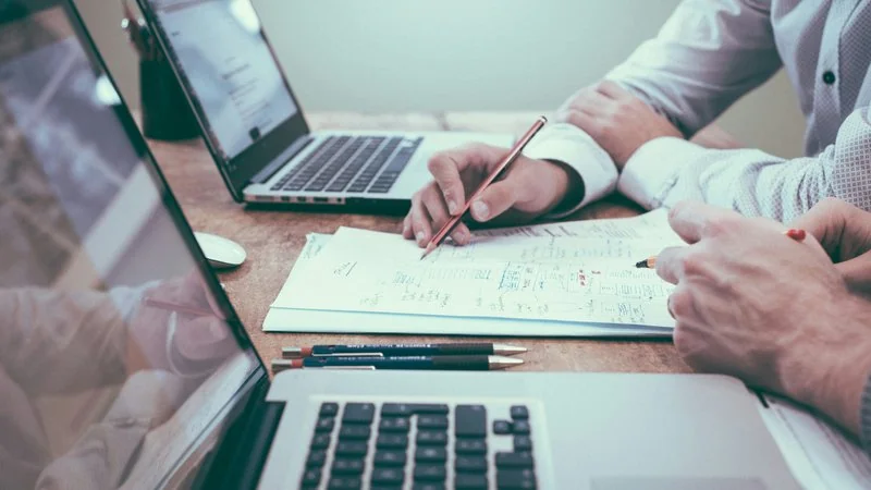 Zwei Personen analysieren handschriftliche Notizen — KI-Strategie erarbeiten