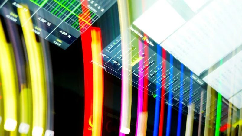 Leuchtend bunte Glasfaserkabel — farbcodierte Netzwerksegmente als VLAN-Metapher